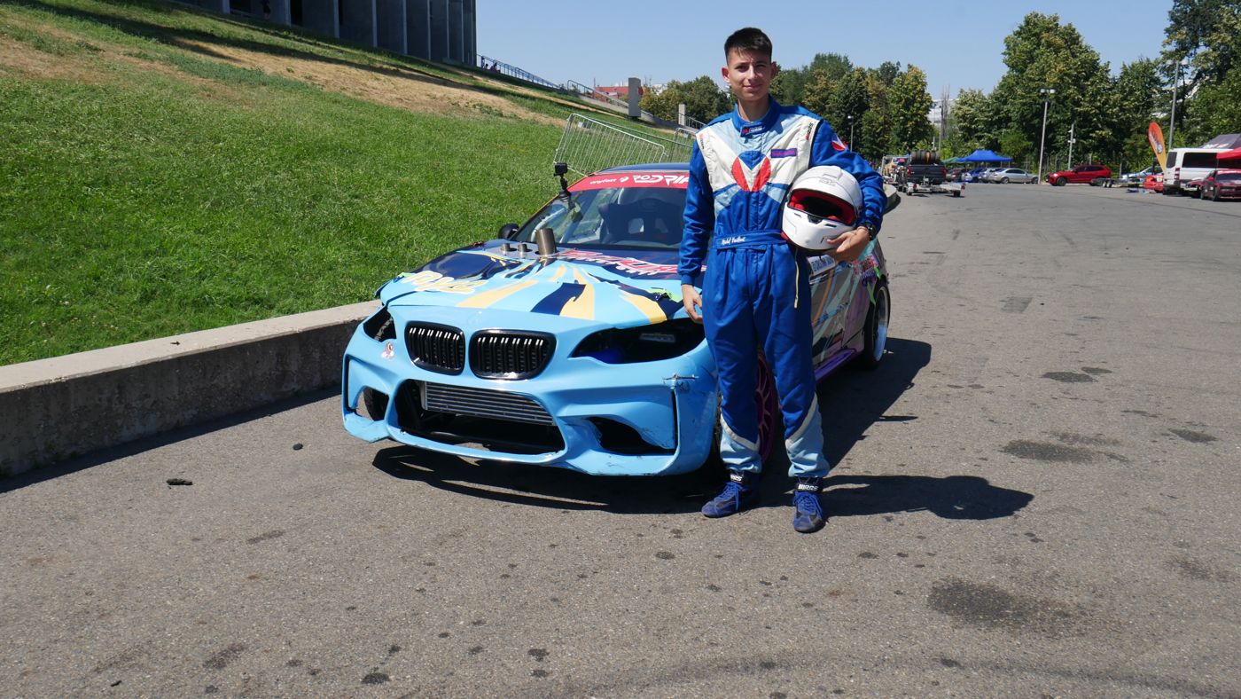 Pilotul Toro Drift lângă mașina de competiție, în paddock